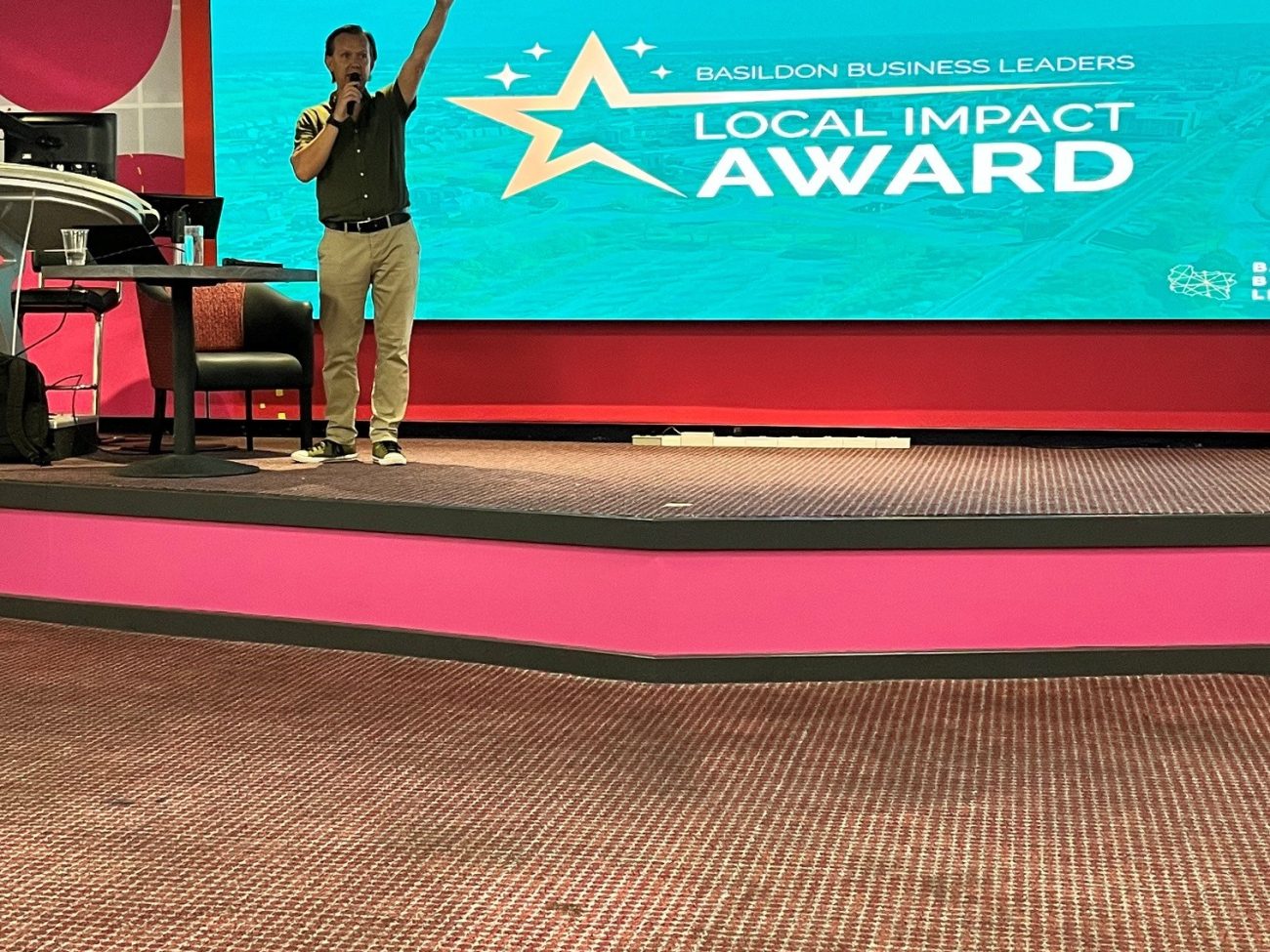 Richard Willis presenting the Basildon Business Leaders Local Impact Award on stage at Buzz Bingo