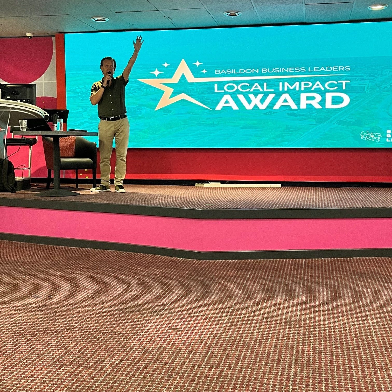 Richard Willis presenting the Basildon Business Leaders Local Impact Award on stage at Buzz Bingo